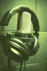 Green colorized microphone with headphones on top